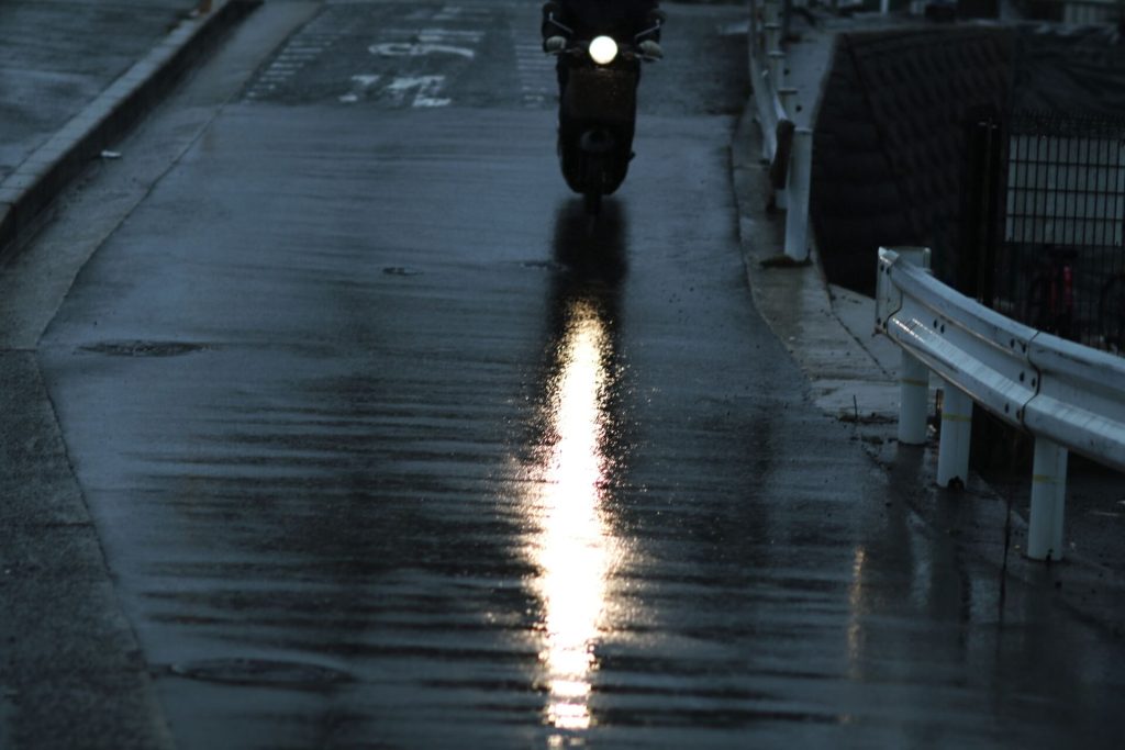 雨の道を走るバイク