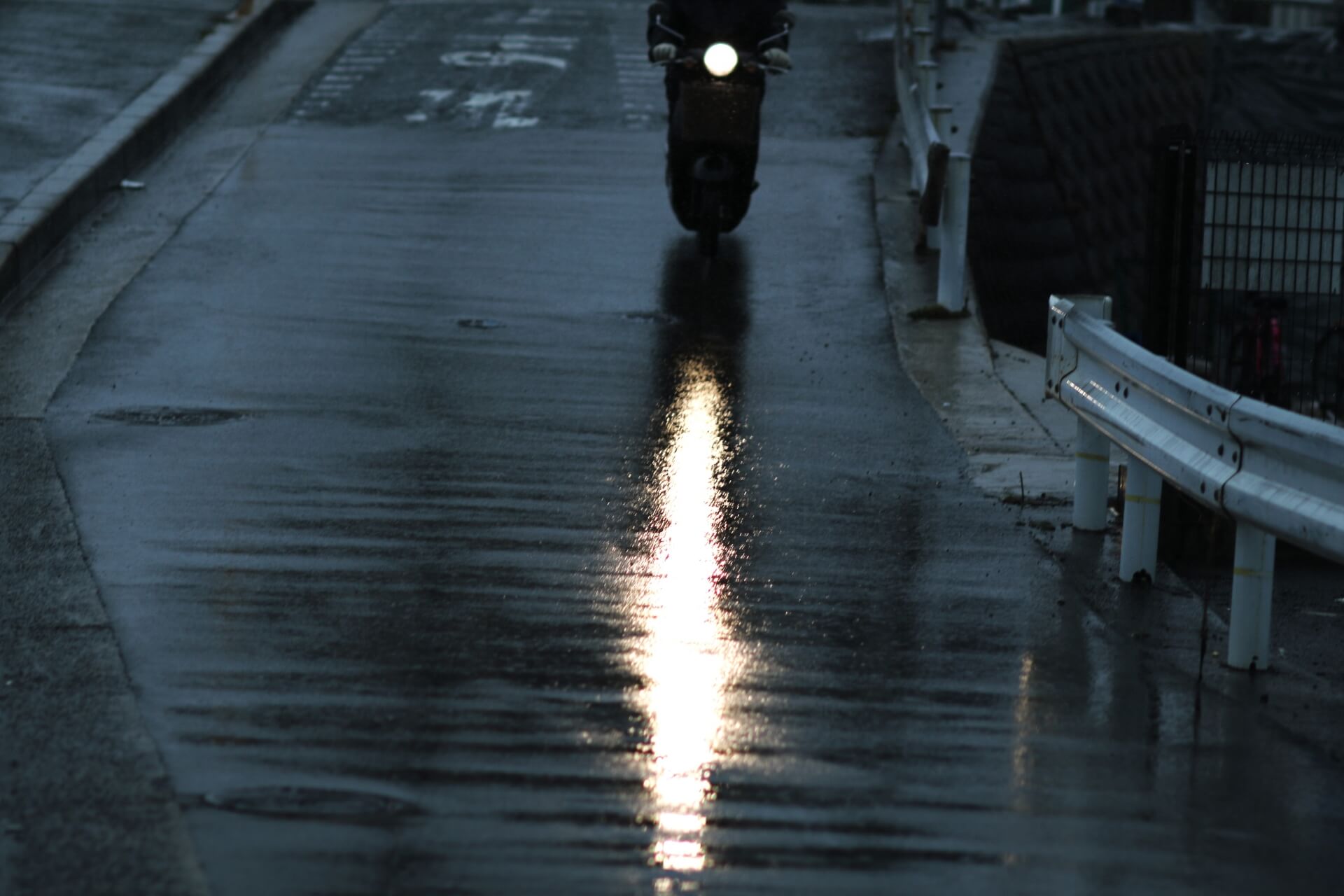 雨の道を走るバイク